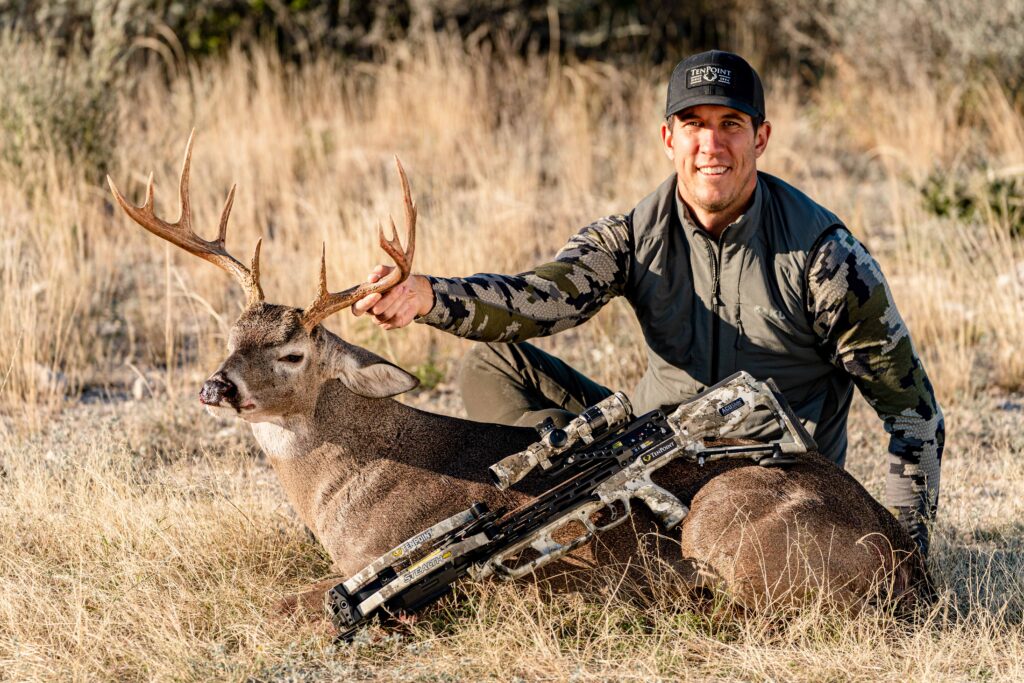 Hunter posing with whitetail buck and TenPoint Stealth 450